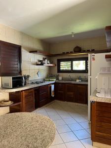 a kitchen with wooden cabinets and a white refrigerator at Casa Brisa do Mar in Pipa
