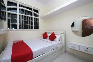 a bedroom with a bed with red pillows and a mirror at Hotel O Atithi Home Stay in Garhā +15 photos