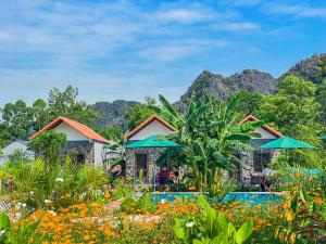 a resort with a garden with flowers and umbrellas at The Sam Home in Nguyên Ngoại