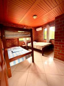a room with two bunk beds and a brick wall at El Faro de los Abuelos in San Bernardo del Viento