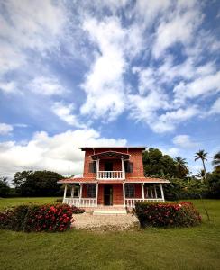 a red brick house with flowers in a field at El Faro de los Abuelos in San Bernardo del Viento