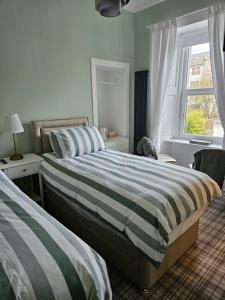 a bedroom with two beds and a window at The Old Bank bed & breakfast in Millport