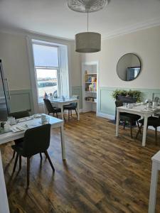 a dining room with white tables and chairs at The Old Bank bed & breakfast in Millport