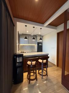 a kitchen with a table and two chairs and a counter at Adi Villa in Darmasaba