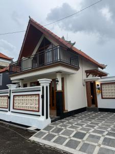 a white house with a balcony and a courtyard at Adi Villa in Darmasaba