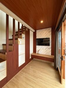 a living room with a staircase and a flat screen tv at Adi Villa in Darmasaba