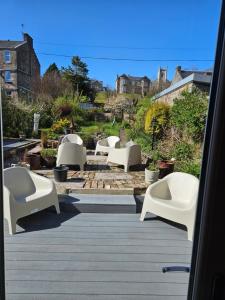 a group of white chairs sitting on a patio at The Old Bank bed & breakfast in Millport