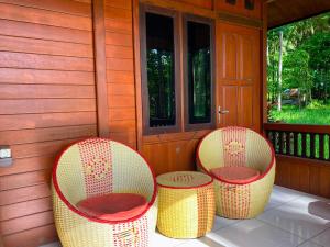 three chairs sitting on the porch of a house at Ghia Boutique Homestay in Batuangus +2 photos