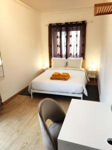 a bedroom with a bed and a chair and a window at Vista Central Amadora in Amadora