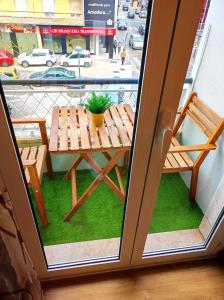 a wooden table with a potted plant sitting on a balcony at Vista Central Amadora in Amadora