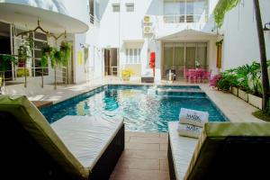 a swimming pool with two chaise lounge chairs next to a building at Malik Hotel Boutique in Cali