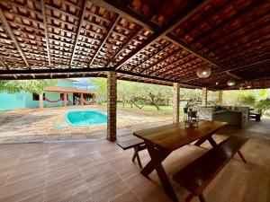 a patio with a wooden table and a swimming pool at Refúgio Santarém in Barreirinhas