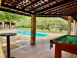 a pool table under a pergola next to a swimming pool at Refúgio Santarém in Barreirinhas