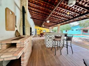 a patio with a bar with chairs and a table at Refúgio Santarém in Barreirinhas