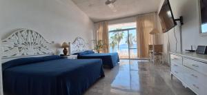 a bedroom with two beds and a large window at PlayaSol las Hadas in Manzanillo