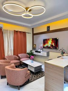 a living room with chairs and a tv on a wall at Residence MBK Studio 1 in Ziguinchor