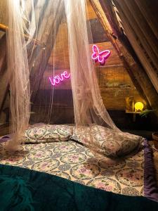 a bedroom with a bed with a sign that says love at Chalé Moon - Vale do ribeira in Juquiá