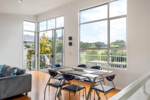 a living room with a table and chairs at Ocean Road Beach House in Whangamata