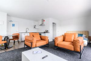 a living room with two chairs and a table at Te Awa Suites in Hamilton