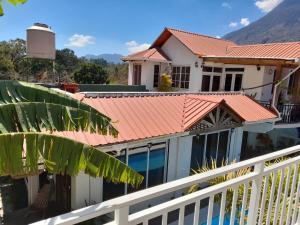 a house with an orange roof and a balcony at Residencias Los Hasses in Santiago Atitlán