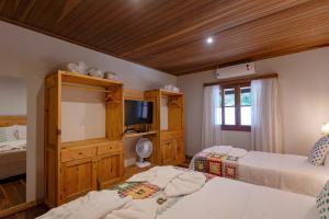 a bedroom with two beds and a flat screen tv at Casa dos Pinheiros in Resende +53 photos