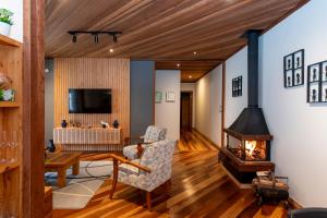 a living room with a fireplace and a tv at Casa dos Pinheiros in Resende