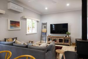 a living room with two couches and a flat screen tv at Ivy Cottage Milton in Milton