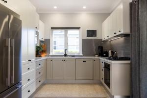 a kitchen with white cabinets and a window at Ivy Cottage Milton in Milton +20 photos