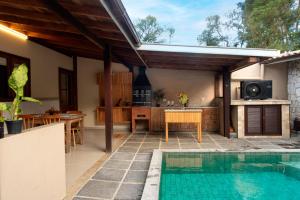 an outdoor kitchen and swimming pool in a house at Casa dos Pinheiros in Resende