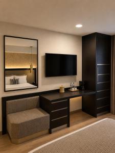 a room with a desk with a tv and a bed at Hotel Catedral in Mexico City