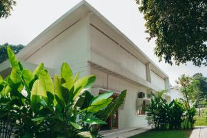 a white building with green plants in front of it at Nong Lam Ecolodge in Linh Xuân Thôn +111 photos