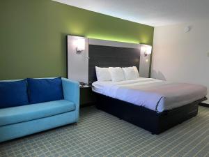 a bedroom with a bed and a blue couch at Quality Inn Seekonk-Providence in Seekonk +23 photos