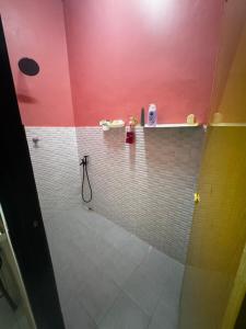 a bathroom with a shower with pink walls and white tiles at LOT 1423 Homestay Lonek-Batu Kikir in Bahau +5 photos