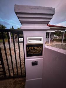a white parking meter in front of a fence at LOT 1423 Homestay Lonek-Batu Kikir in Bahau