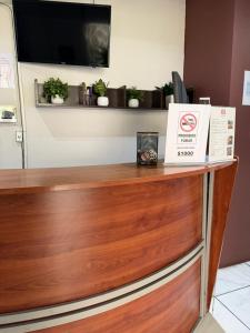 a wooden counter with a tv on top of it at Hotel La Frontera in Ciudad Juárez