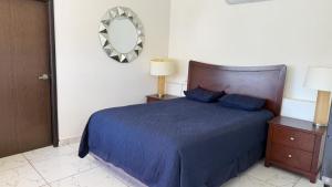 a bedroom with a blue bed and a mirror at Hotel La Frontera in Ciudad Juárez