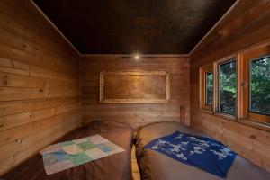a room with two beds in a log cabin at Kussharoko Artemina Log Terrace in Kotan