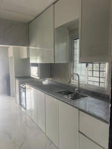 a kitchen with white cabinets and a sink at Raqsea House in Monrovia