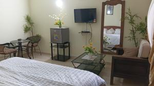 a bedroom with a bed and a table and a mirror at Providence Guest house and Catering Services 01 in Abidjan