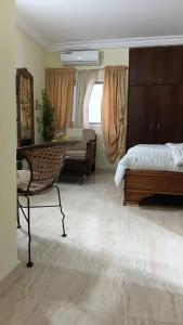 a bedroom with a bed and a chair and a table at Providence Guest house and Catering Services 01 in Abidjan