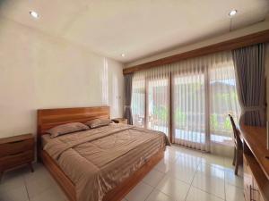 a bedroom with a bed and a large window at The sonteng hills in Sengkol