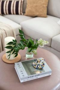 a table with a book and a vase of flowers on it at The J Luxury Apartments Near Mahane Yehuda - Perfect for Shabbat Stays in Jerusalem