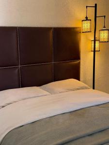 a bedroom with a large bed with two lights on it at Casa privada con estacionamiento in Hermosillo