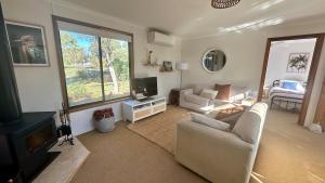 a living room with a couch and a tv at The Deck @ VB - Linen, Wi-Fi, Pets, Secured Yard in Venus Bay