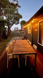 a wooden table and chairs on a deck at The Deck @ VB - Linen, Wi-Fi, Pets, Secured Yard in Venus Bay