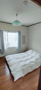 a large white bed in a room with a window at The Lodge In Sapporo in Sapporo