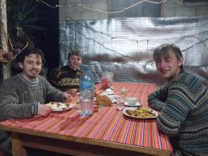 a group of three men sitting at a table eating food at Salkantay Wasi in Colcapampa