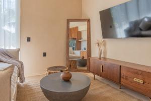 a living room with a coffee table and a mirror at Luxury Penthouse, Rooftop Pool and Lagoon in Bacalar