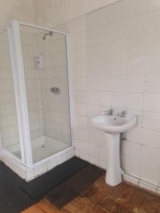 a white bathroom with a sink and a shower at Lisokhanya GuestHouse in East London +67 photos