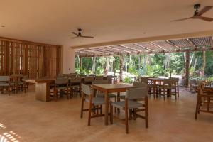 a dining room with tables and chairs and trees at Luxury Penthouse, Rooftop Pool and Lagoon in Bacalar